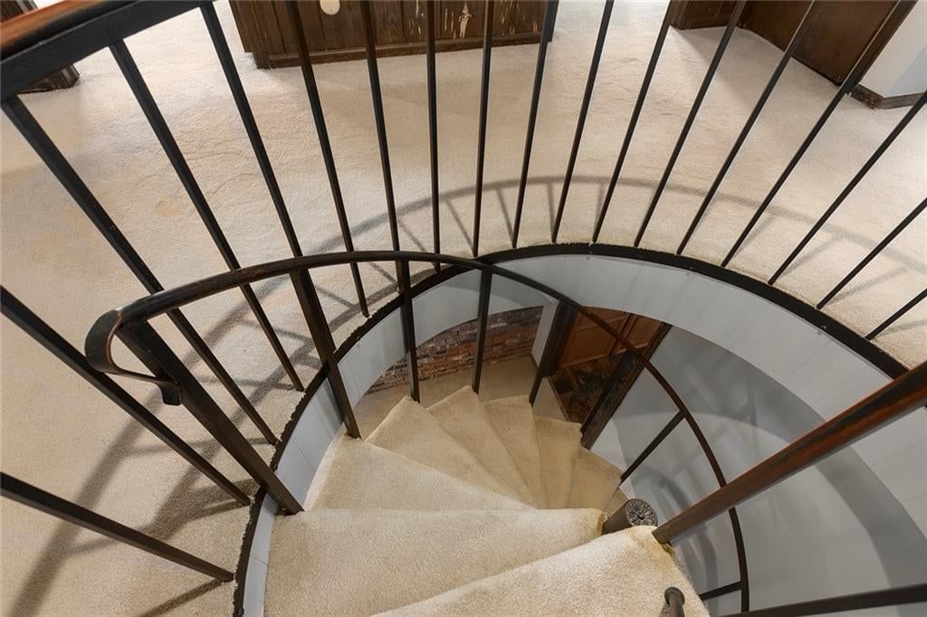 Curved staircase, staircase and iron stair railing at 7616 NW Eastside Drive, Weatherby Lake, MO 64152
