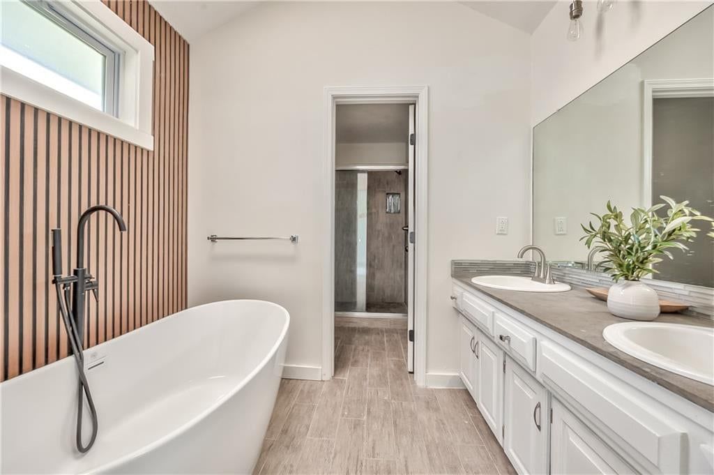 Wainscoting or board and batten, shiplap / paneling and freestanding tub at 1105 Brookside Place, Raymore, MO 64083