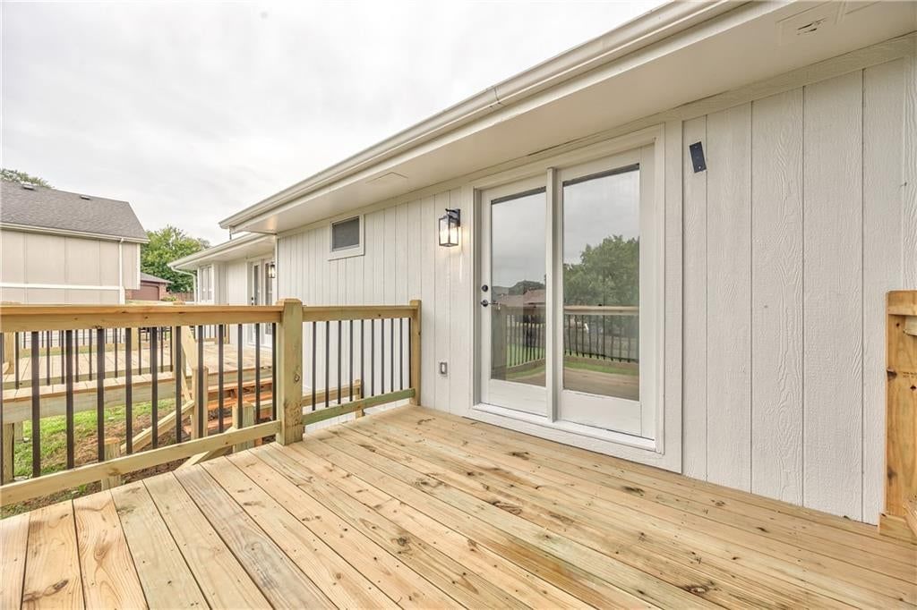 Deck, big backyard and mature trees at 1105 Brookside Place, Raymore, MO 64083