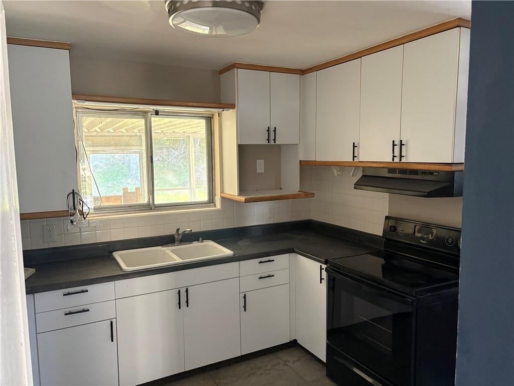 White kitchen, quartz counters and updated kitchen at 4724 N Bristol Avenue, Kansas City, MO 64117