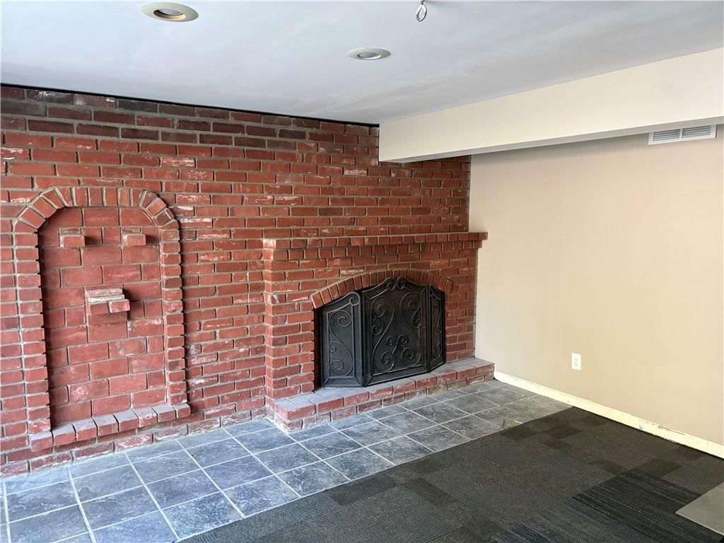 Fireplace, exposed brick wall and tile floors at 4724 N Bristol Avenue, Kansas City, MO 64117