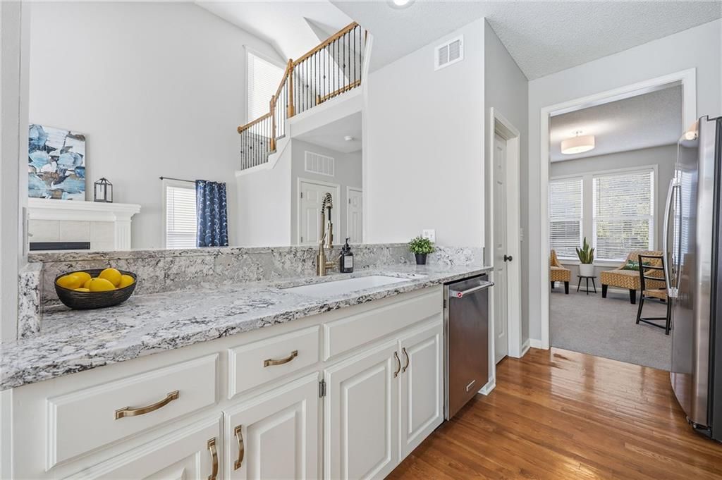White kitchen, granite counters and stainless steel appliances at 2325 W Piatt Lane, Olathe, KS 66061