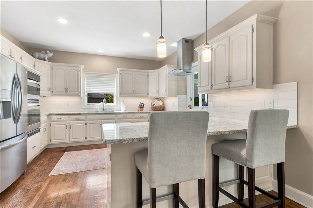 Kitchen island, white kitchen and quartz counters at 15592 S Greenwood Street, Olathe, KS 66062
