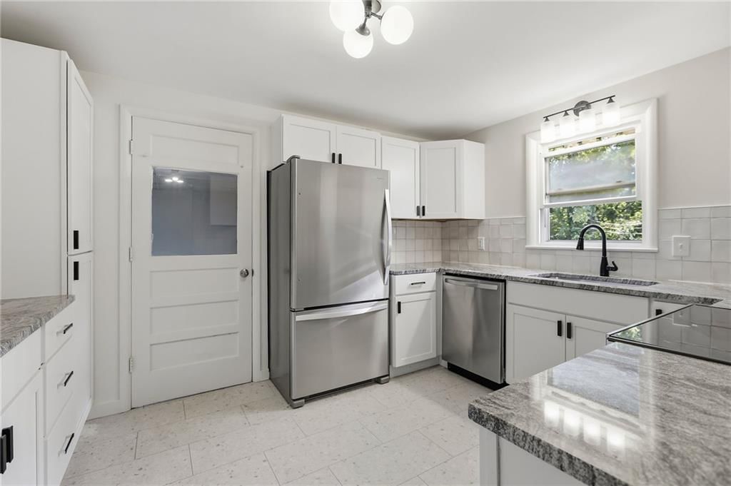 White kitchen, granite counters and shaker cabinets at 5909 Melrose Lane, Shawnee, KS 66203