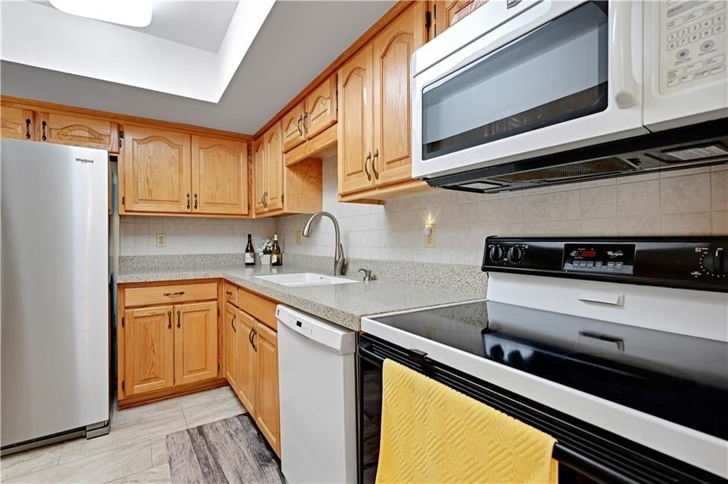Stainless steel appliances, wood kitchen cabinets and electric range at 9623 Reeder Street, Overland Park, KS 66214