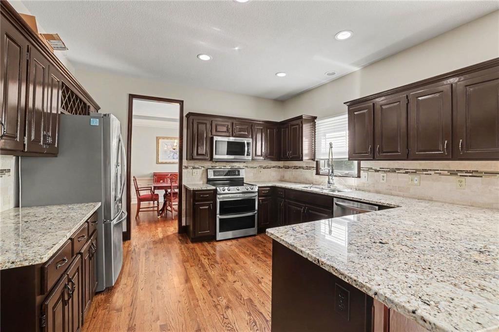 Kitchen island, granite counters and kitchen backsplash at 9913 W 125th Terrace, Overland Park, KS 66213