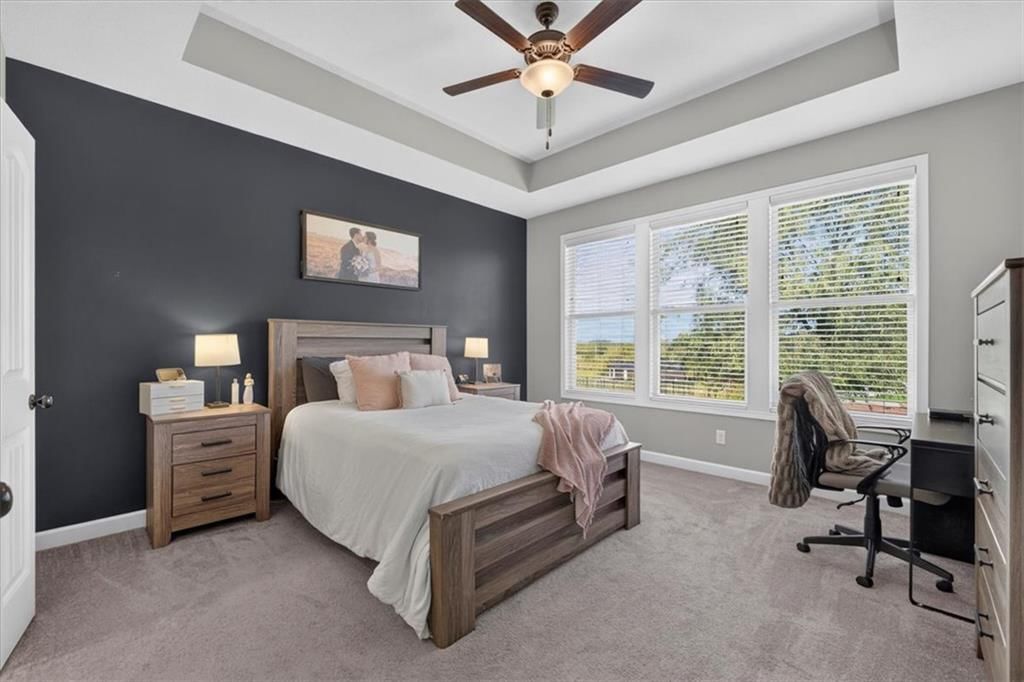 Main-floor primary bedroom, accent wall and carpet at 504 Bentwater Drive, Raymore, MO 64083
