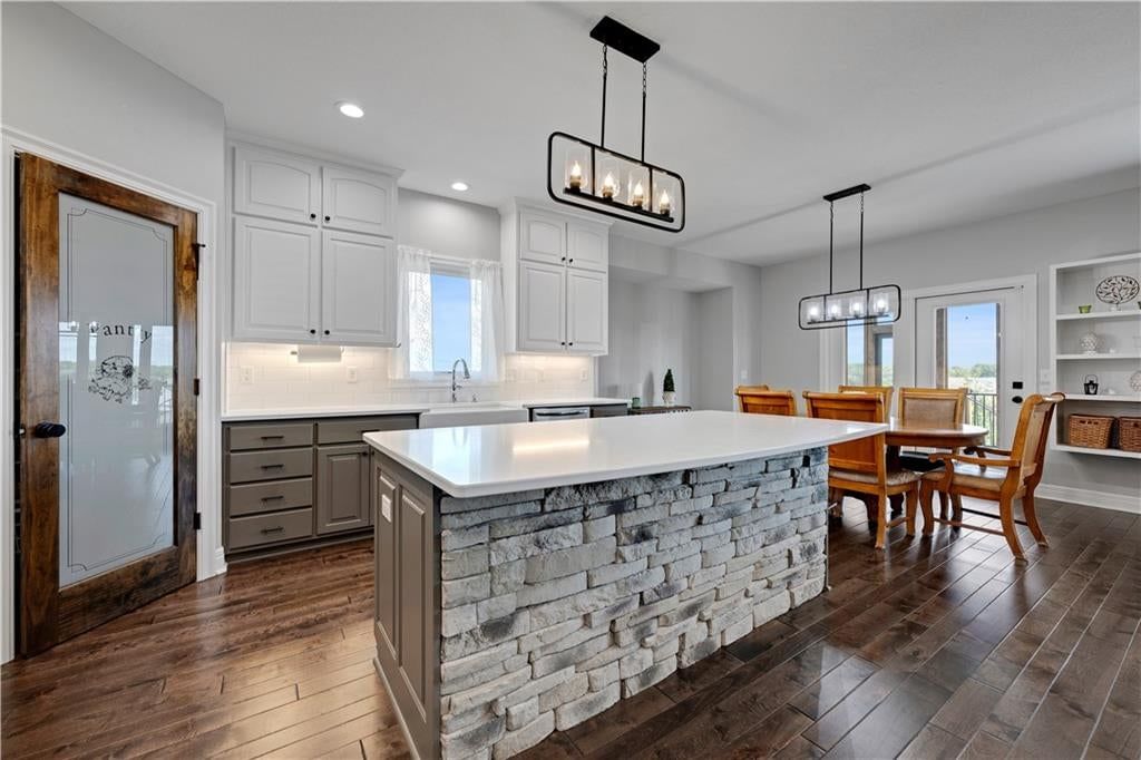 Kitchen island, quartz counters and statement lighting at 8311 Pickering Street, Lenexa, KS 66227