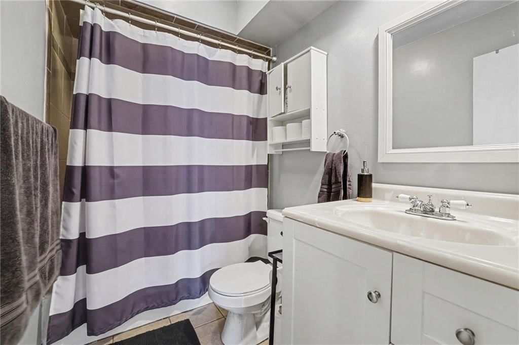 Tiled shower, white vanity and renovated bathrooms at 2018 E Mohawk Court, Olathe, KS 66062