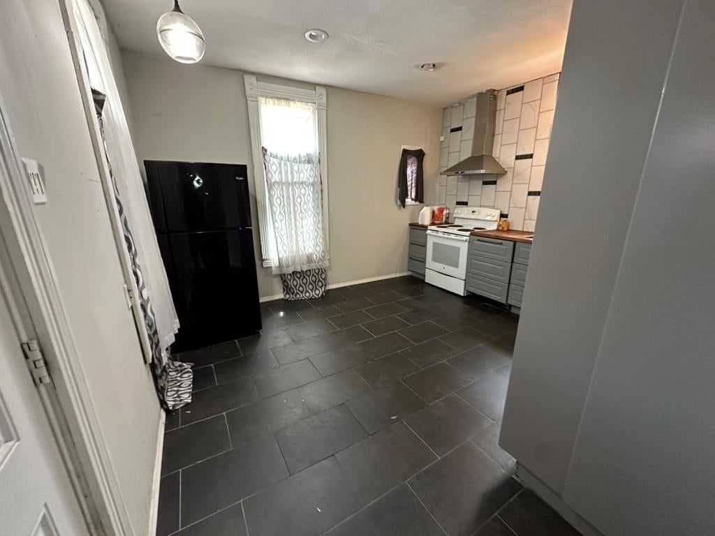 Open floor plan, tile floors and black appliances at 2807 7th Street E, Kansas City, MO 64124
