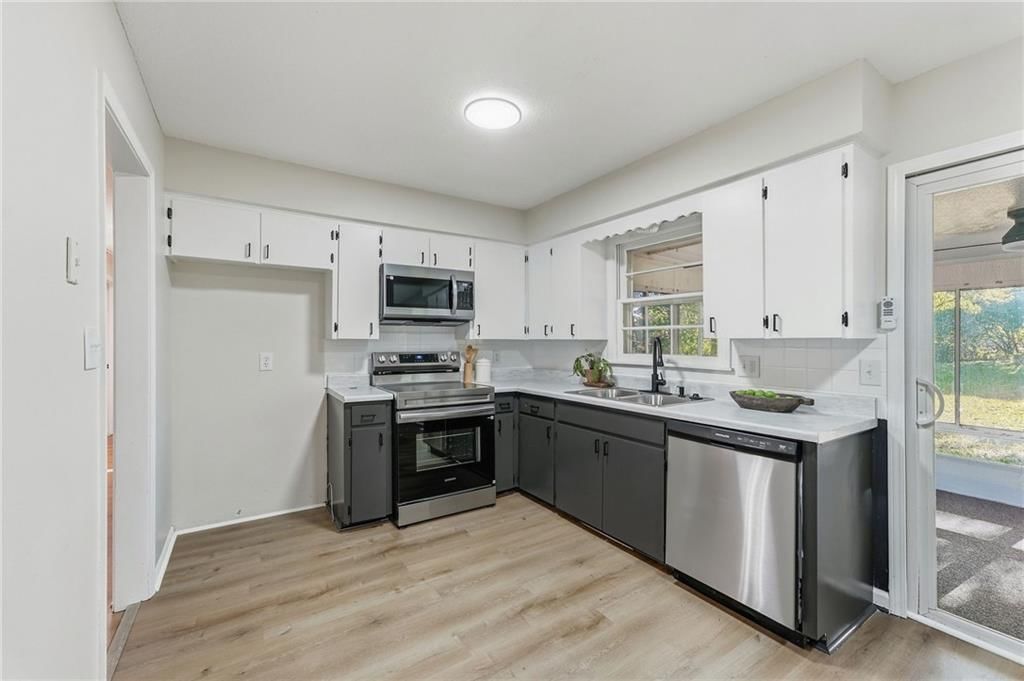 Two-tone kitchen cabinets, stainless steel appliances and kitchen backsplash at 1913 N Plymouth Road, Independence, MO 64058
