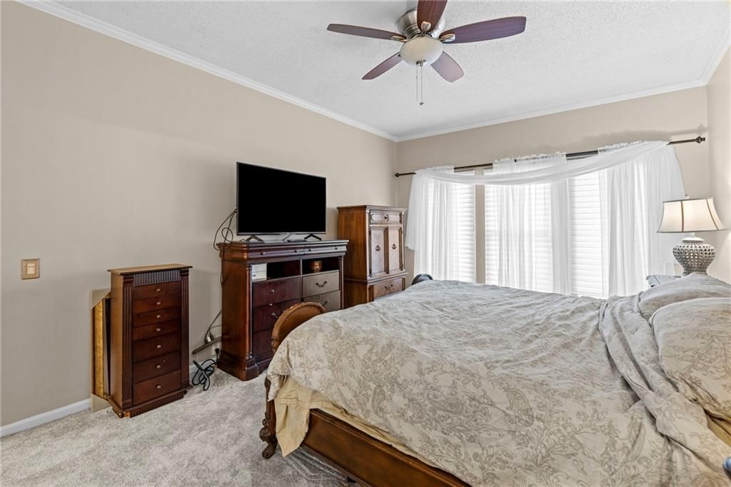 Main-floor primary bedroom and carpet at 628 NE 93rd Street, Kansas City, MO 64155
