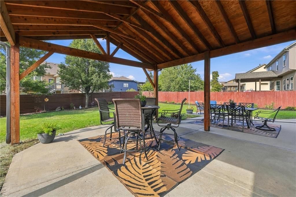 Fenced yard, mature trees and wood fence at 110 S Eastglen Drive, Raymore, MO 64083