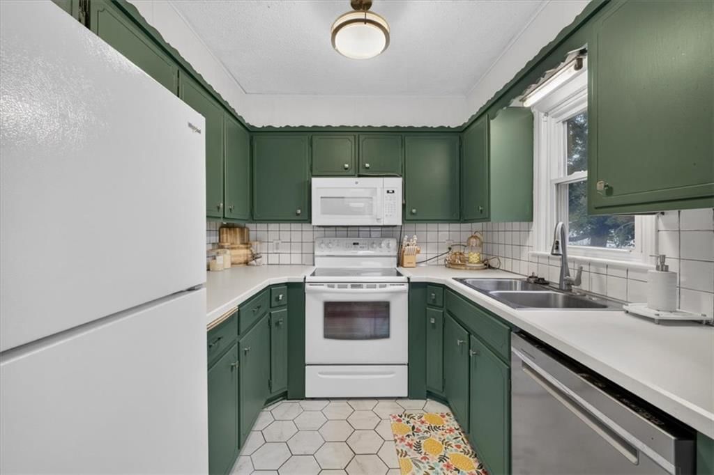Quartz counters, statement lighting and green kitchen cabinets at 3611 S Spring Street, Independence, MO 64055