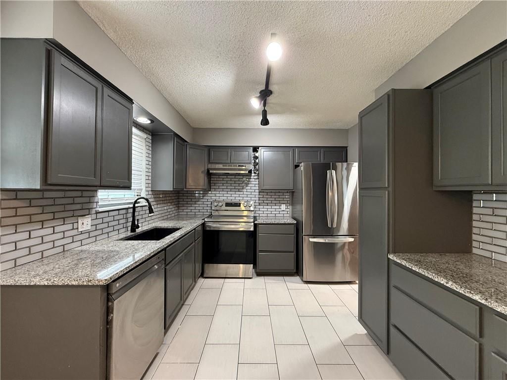 Open floor plan, statement lighting and tile floors at 1415 W Ferrel Drive, Olathe, KS 66061