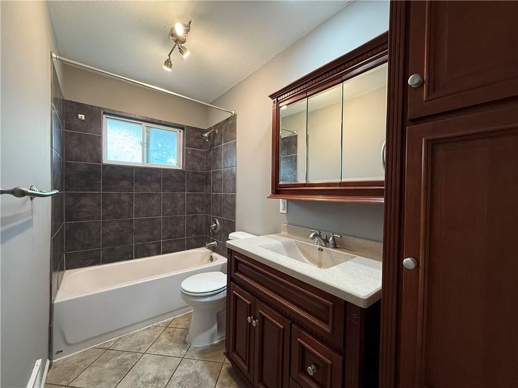 Tiled shower, gray vanity and renovated bathrooms at 1415 W Ferrel Drive, Olathe, KS 66061