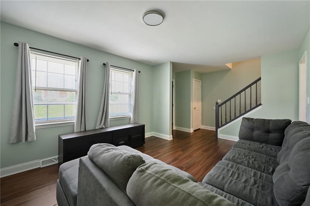 Open floor plan, hardwood floors and wall of windows at 6208 E 129th Street, Grandview, MO 64030