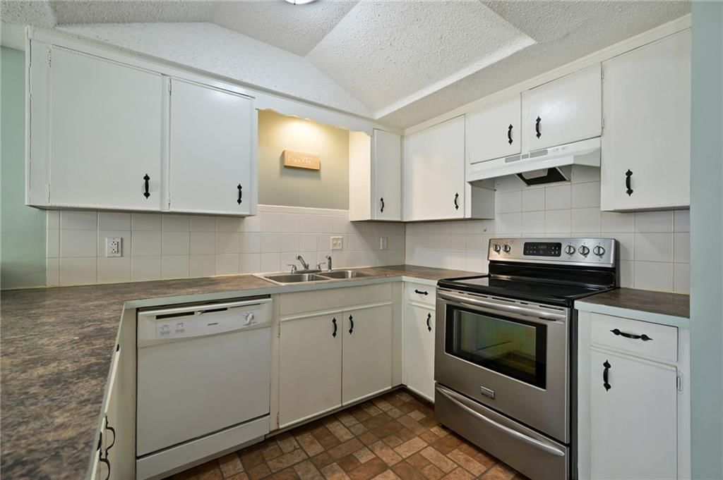 White kitchen, granite counters and shaker cabinets at 6208 E 129th Street, Grandview, MO 64030