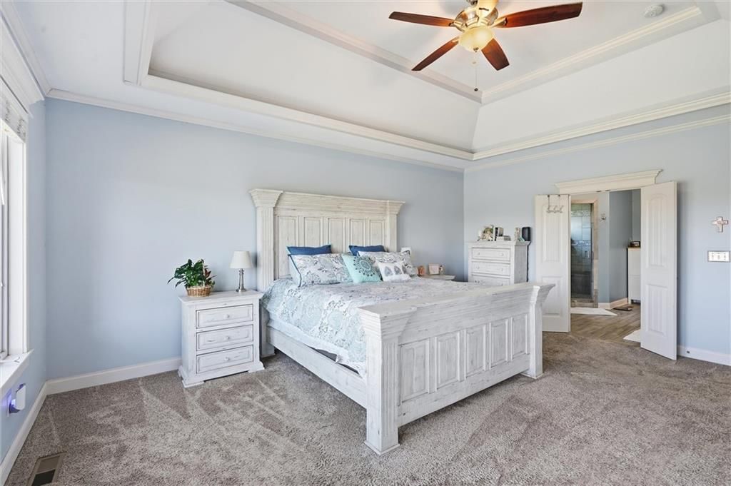 Main-floor primary bedroom and carpet at 13012 E Lone Jack Lee's Summit Road, Lone Jack, MO 64086