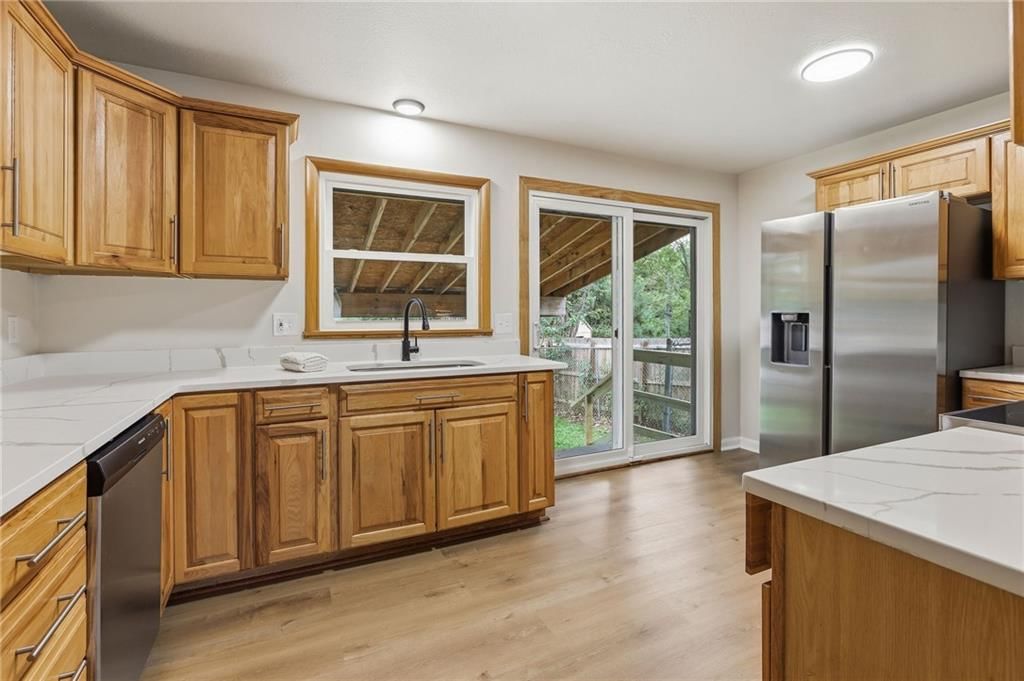 Stainless steel appliances, wood kitchen cabinets and white countertops at 408 N Kirk Avenue, Independence, MO 64050