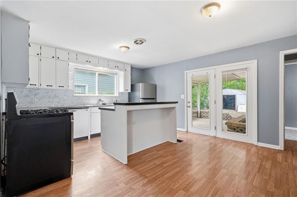 Open floor plan, kitchen island and white kitchen at 412 S Hocker Avenue, Independence, MO 64050