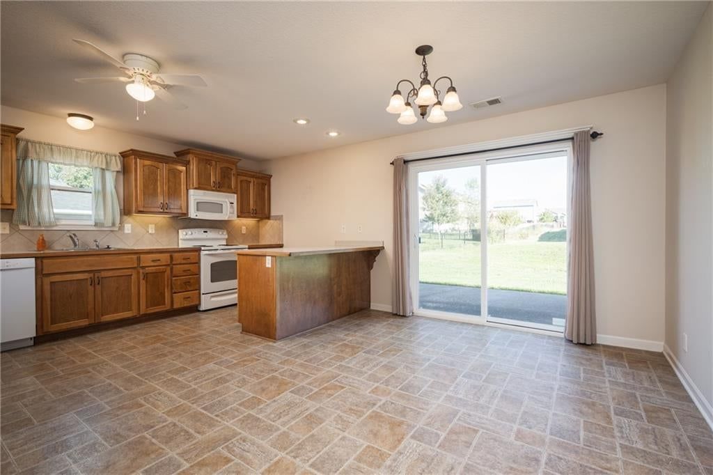 Kitchen island, breakfast nook and wood kitchen cabinets at 101 Sun Garden Street, Blue Springs, MO 64064