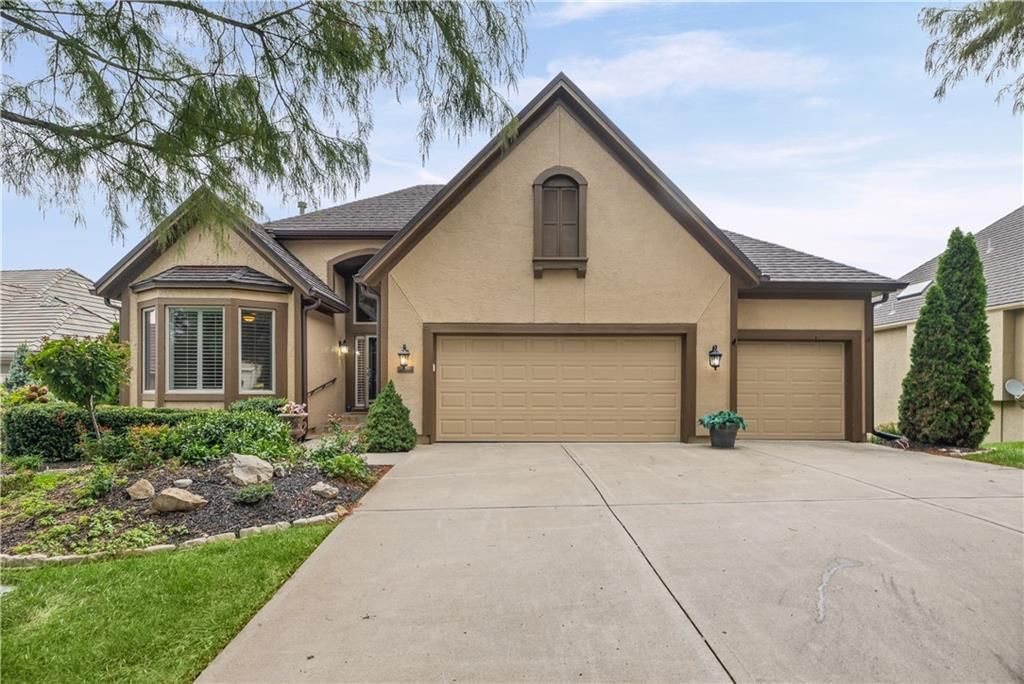 Attached garage, concrete driveway and garage for three or more cars at 20306 W 99th Terrace, Lenexa, KS 66220