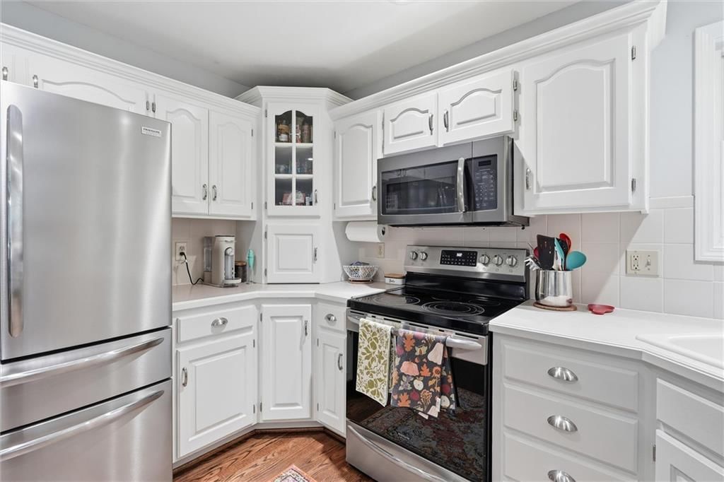Kitchen island, white kitchen and quartz counters at 1104 Regency Drive, Kearney, MO 64060
