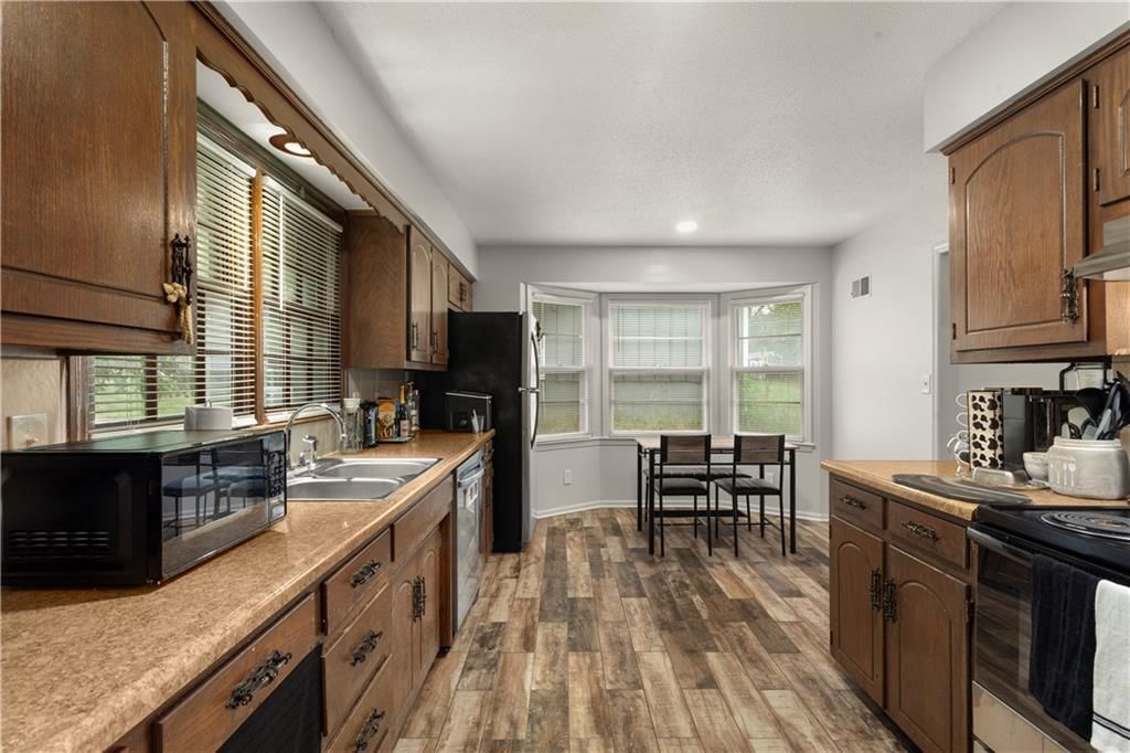 Open floor plan, luxury vinyl floors and wall of windows at 8435 E 56th Terrace, Kansas City, MO 64129