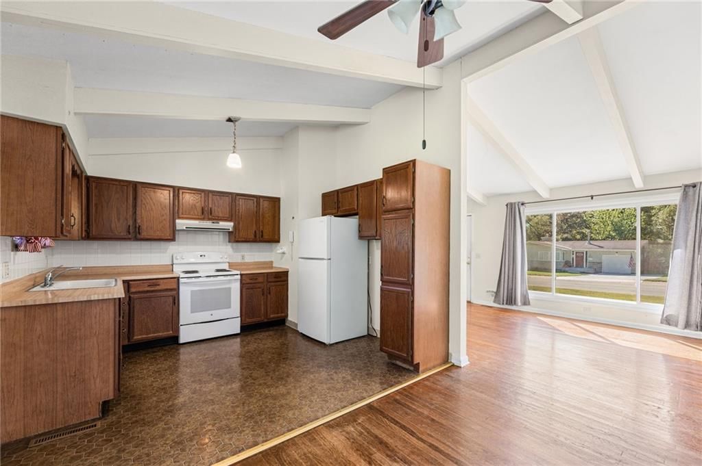 Wood kitchen cabinets, white appliances and electric range at 5718 W 75th Terrace, Prairie Village, KS 66208
