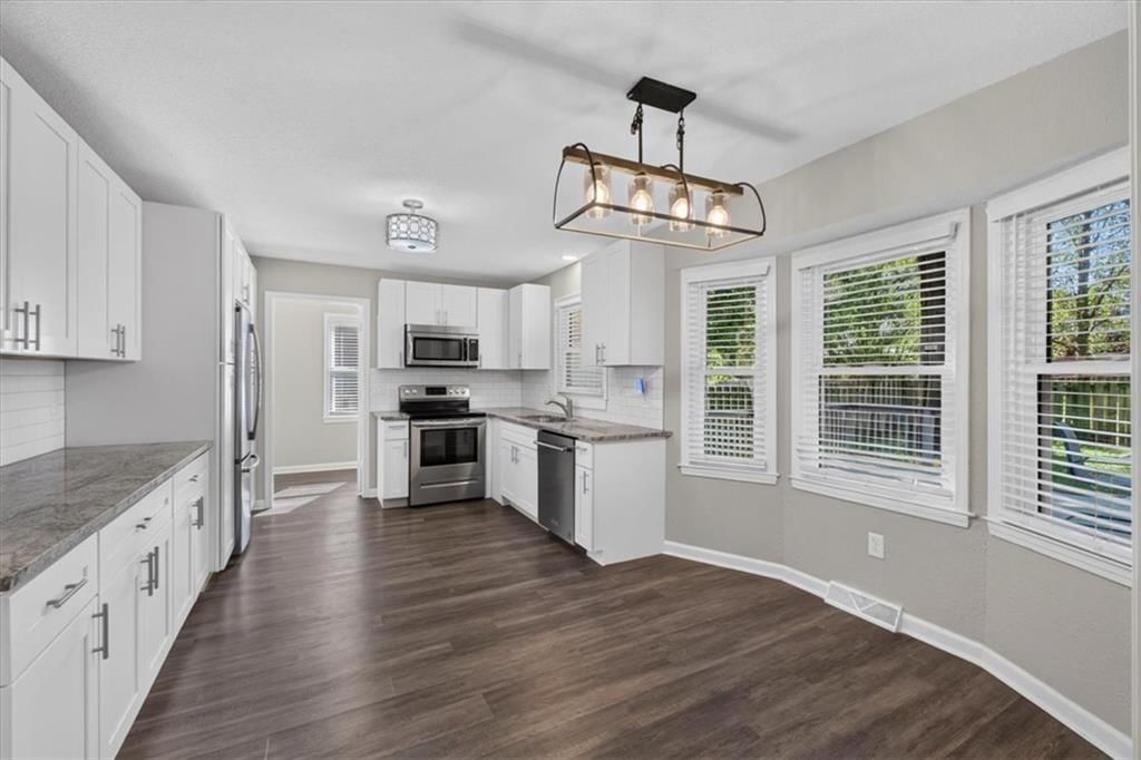 White kitchen, granite counters and shaker cabinets at 406 SE Richardson Place, Lee's Summit, MO 64063