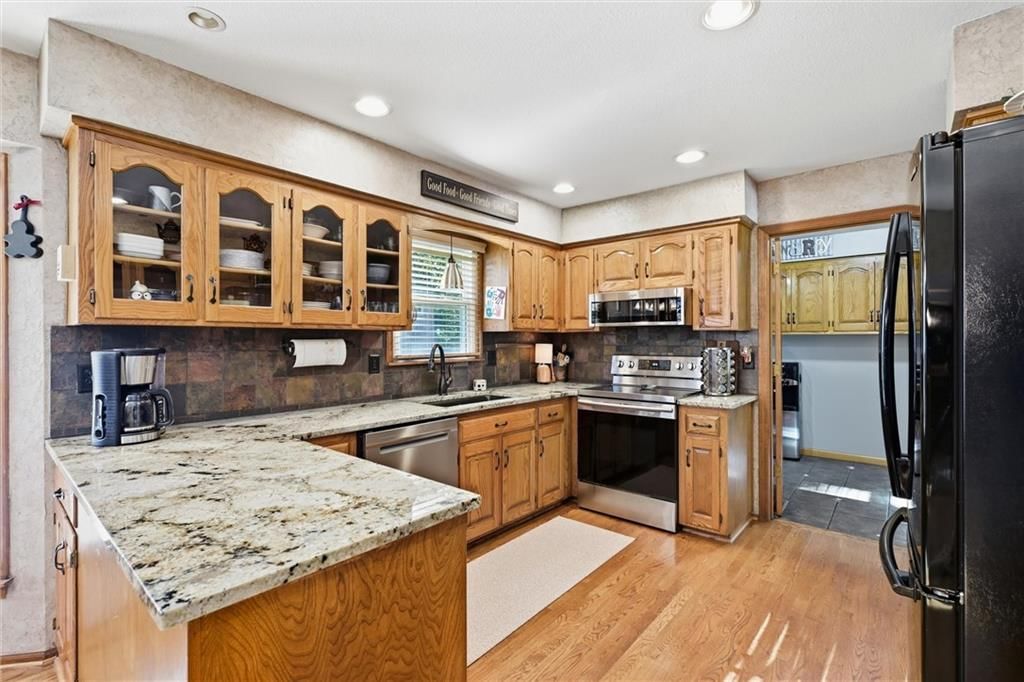 Granite counters and wood kitchen cabinets at 14715 S Arapaho Drive, Olathe, KS 66062