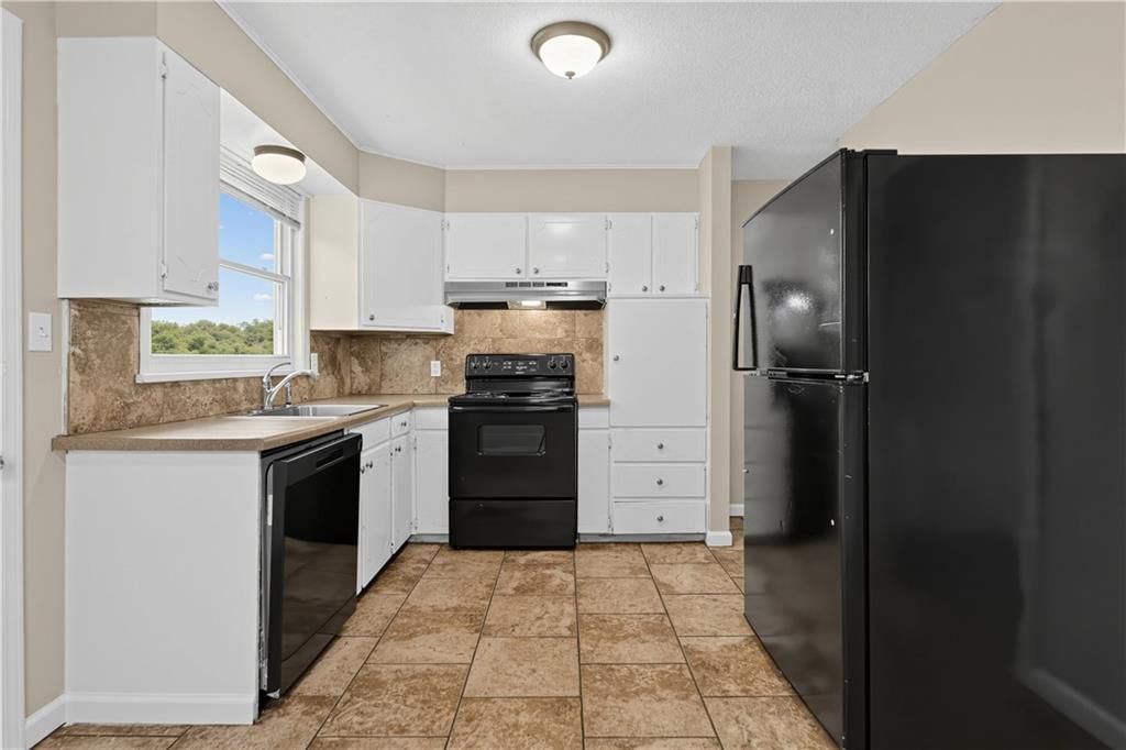 Open floor plan, white kitchen and electric range at 11727 FREMONT Avenue, Kansas City, MO 64134