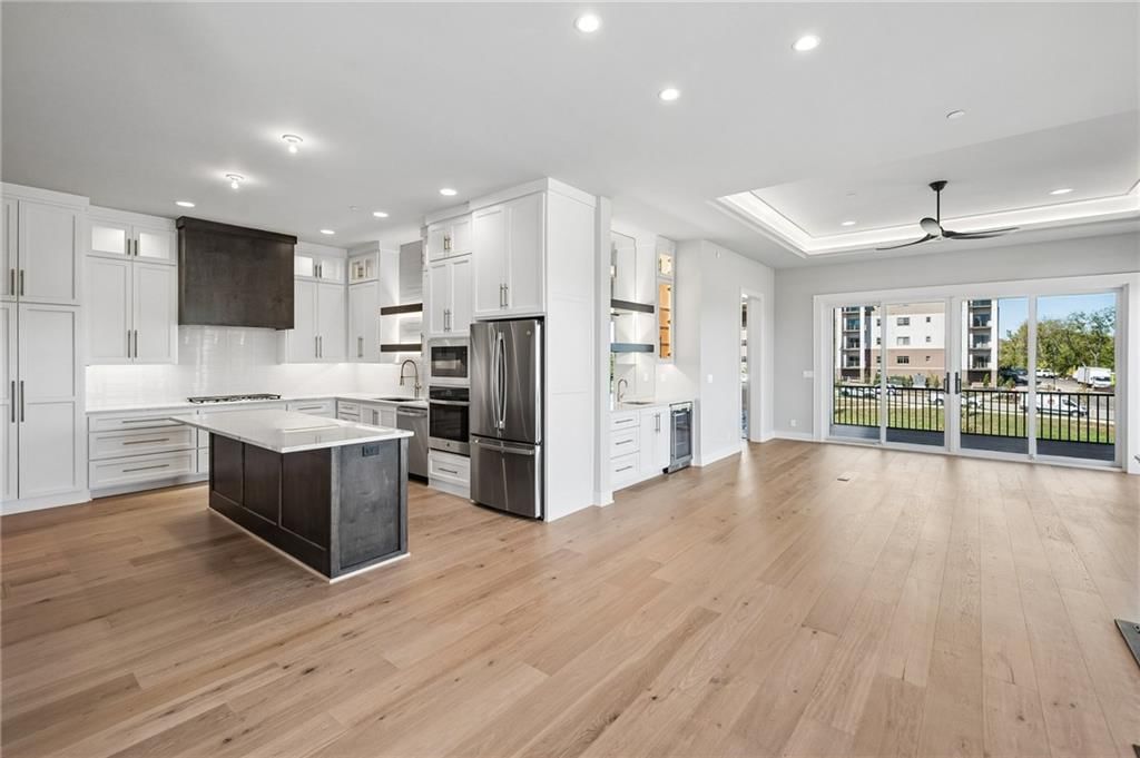 Open floor plan, kitchen island and white kitchen at 13727 Pembroke Lane, Leawood, KS 66224