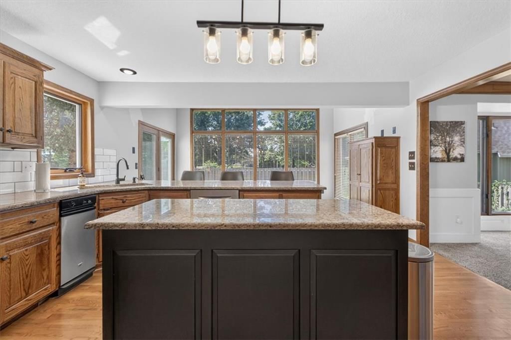 Kitchen island, hardwood floors and statement lighting at 713 NW Eagle Ridge Circle, Lee's Summit, MO 64081