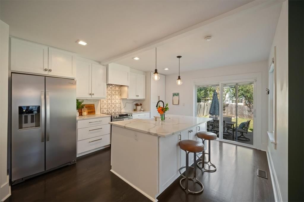 Kitchen island, white kitchen and quartz counters at 8639 Maiden Lane, Kansas City, MO 64114