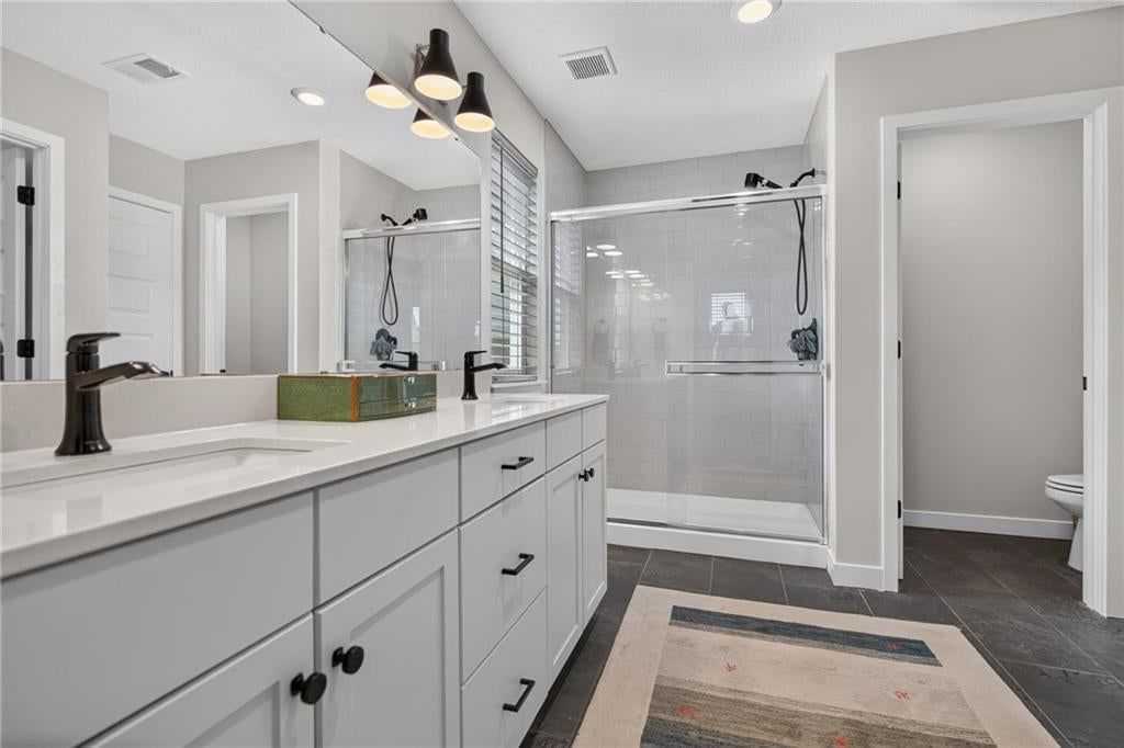 Walk-in shower, private toilet room and tiled shower at 18068 Hauser Street, Overland Park, KS 66013