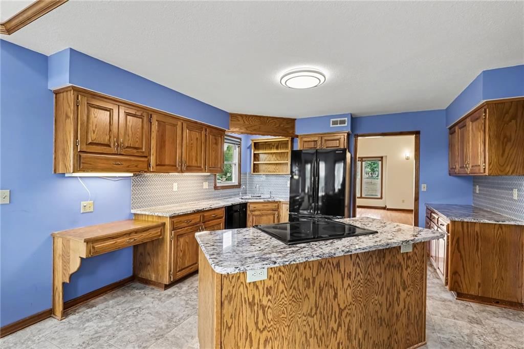 Kitchen island, granite counters and kitchen backsplash at 26503 283rd Street, Harrisonville, MO 64701