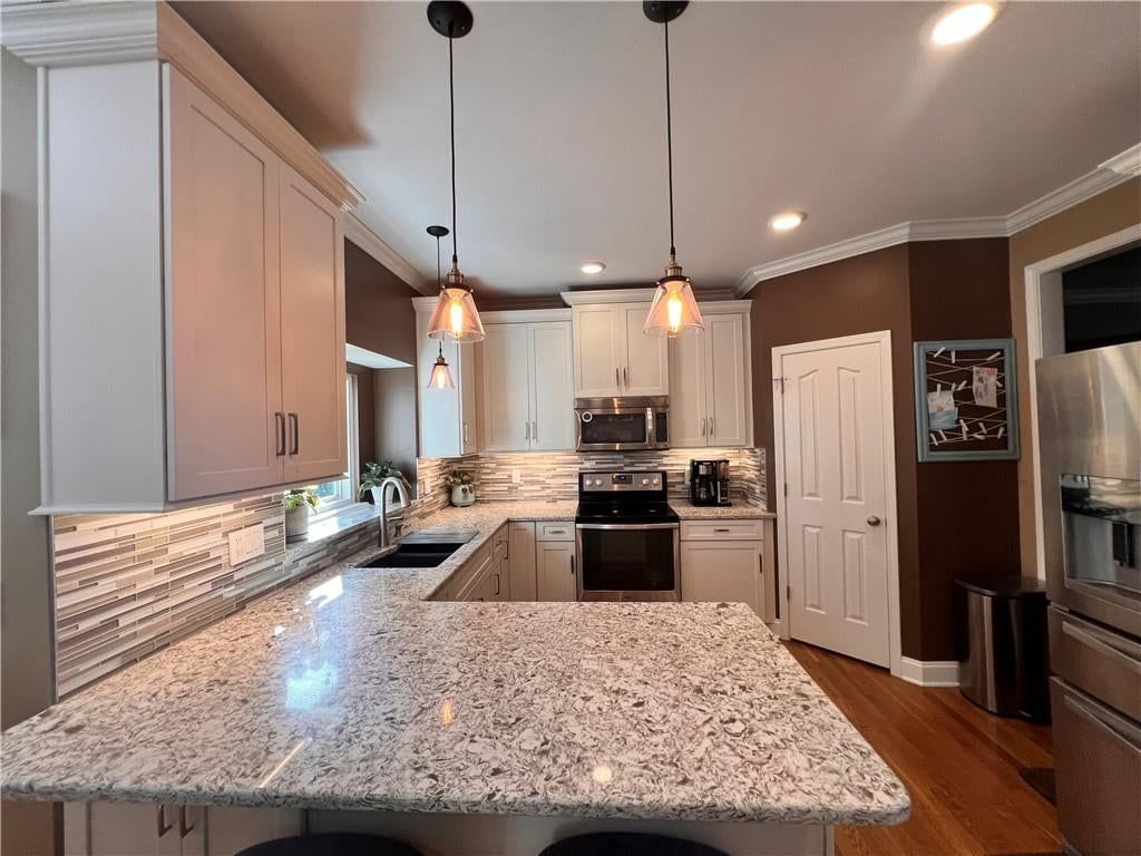 Kitchen island, white kitchen and granite counters at 541 E Mockingbird Street, Gardner, KS 66030