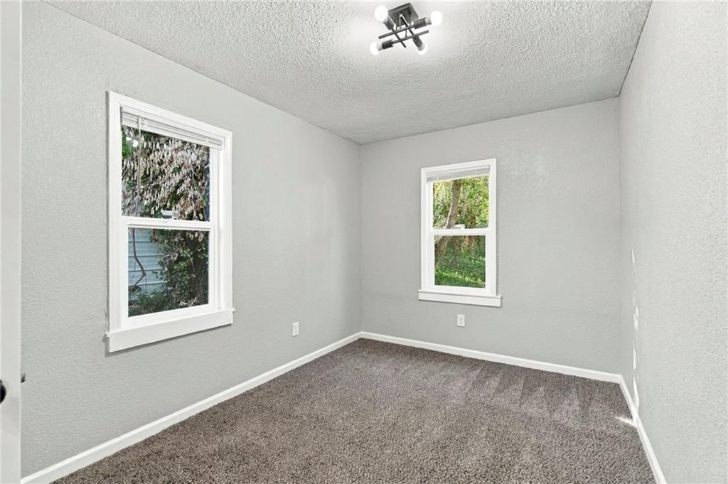 Carpet and main-floor primary bedroom at 15023 E Truman Road, Independence, MO 64050