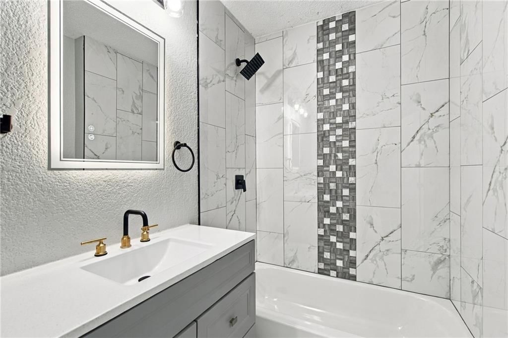 Tiled shower and renovated bathrooms at 15023 E Truman Road, Independence, MO 64050