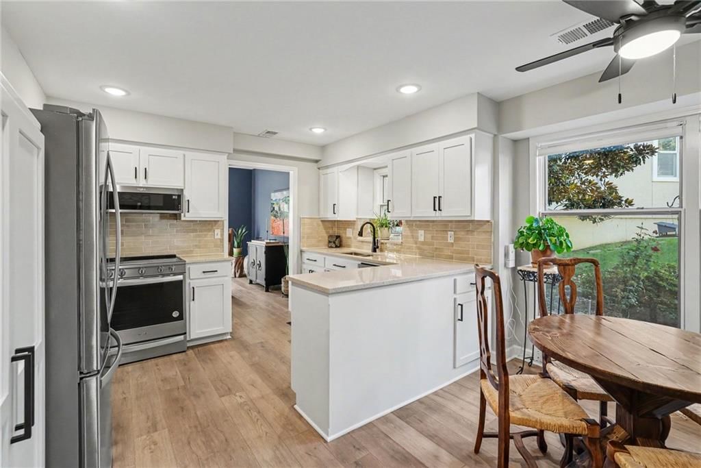 Open floor plan, kitchen island and white kitchen at 12201 Caenen Drive, Overland Park, KS 66213
