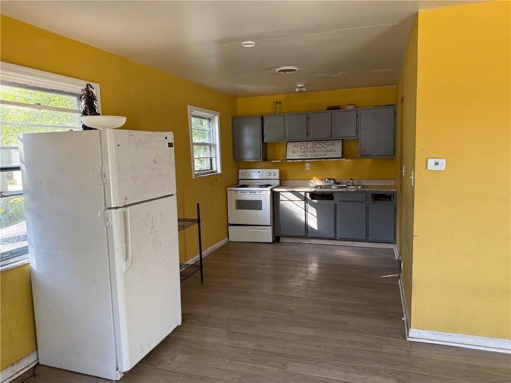 Gray kitchen cabinets, white appliances and electric range at 4738 Woodend Avenue, Kansas City, KS 66106