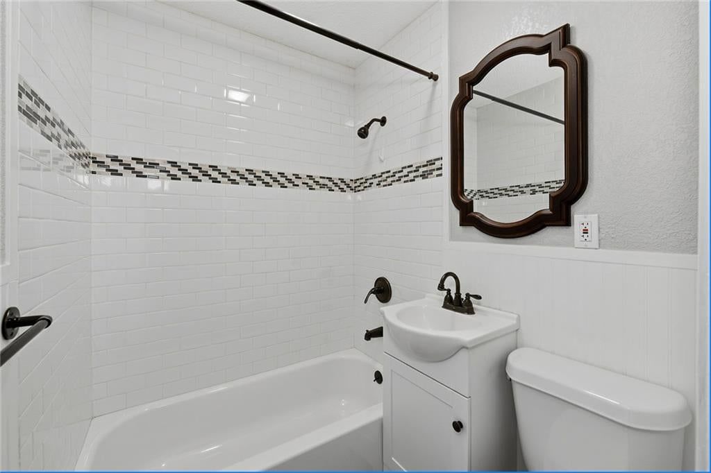 Tiled shower and white vanity at 124 S Myrtle Street, Excelsior Springs, MO 64024