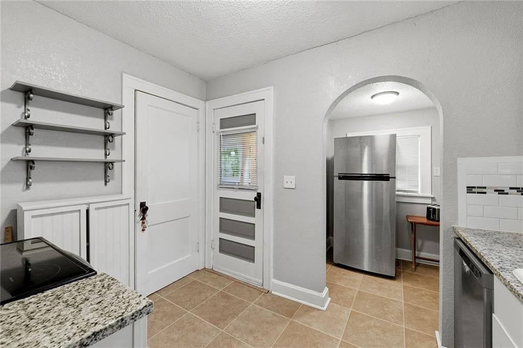 Kitchen open to the living area, white kitchen and granite counters at 124 S Myrtle Street, Excelsior Springs, MO 64024