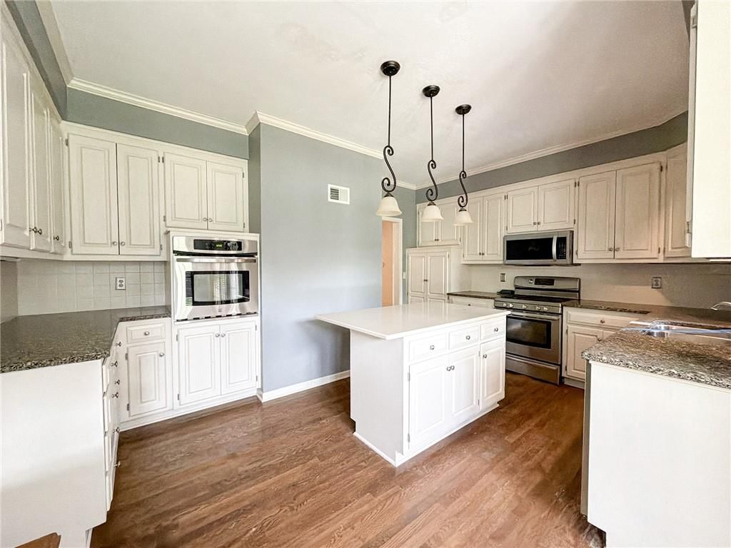 Kitchen island, gas range and double oven at 6836 Glenwood Street, Overland Park, KS 66204