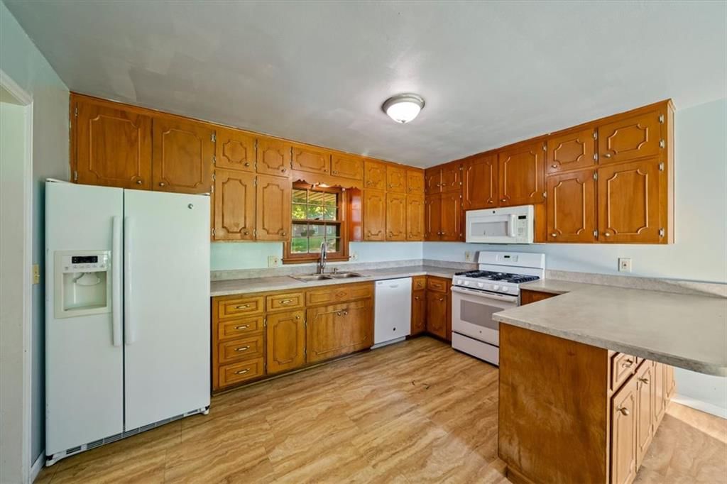 Gas range, breakfast nook and wood kitchen cabinets at 2611 N 83rd Street, Kansas City, KS 66109