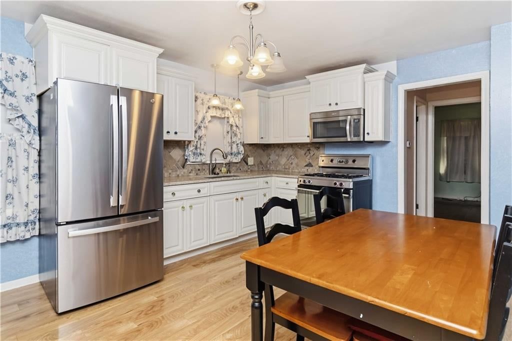 White kitchen, gas range and stainless steel appliances at 9643 McGee Street, Kansas City, MO 64114