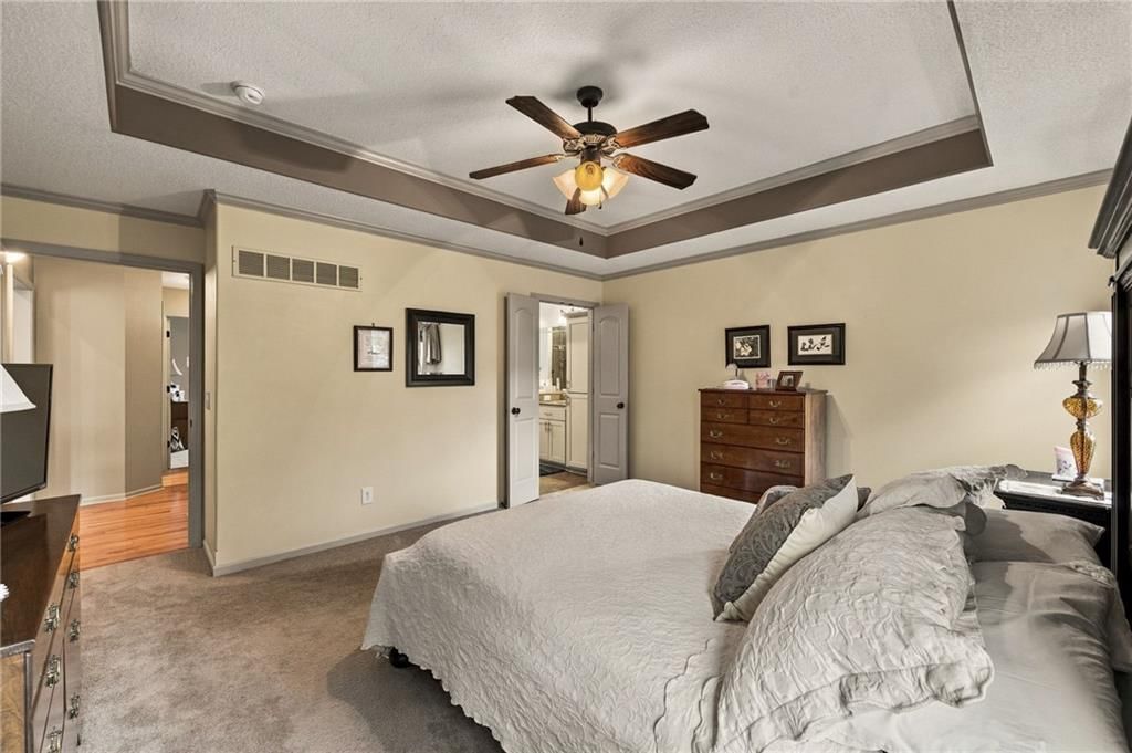 Main-floor primary bedroom, tray ceiling and black hardware at 343 SE WOOD Lane, Lee's Summit, MO 64063