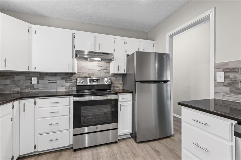 White kitchen, kitchen backsplash and black countertops at 2200 Aqueduct Place, Independence, MO 64057